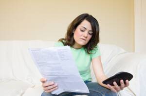 Junge Frau schaut auf Rechnung