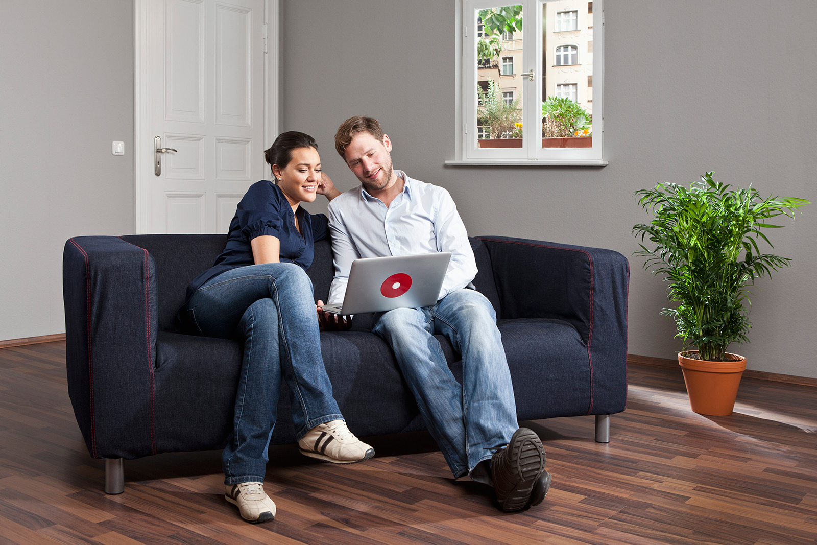 Ehepaar auf Couch mit Laptop